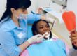 Dental insurance important - dental nurse with happy patient looking in mirror